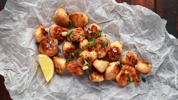 Scallops seared in garlic and parsley butter served on crumpled paper